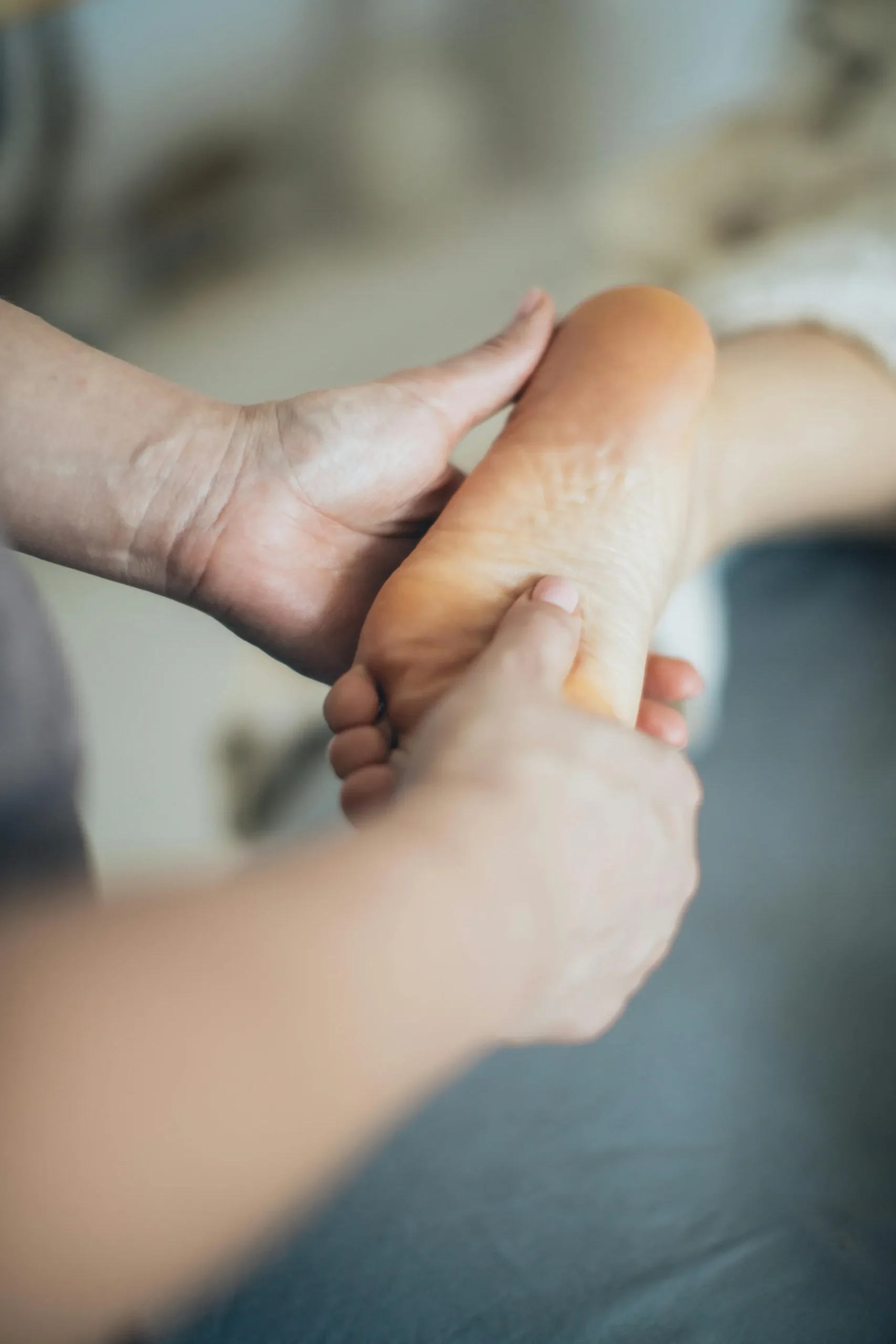 Técnica de reflexologia podal aplicada em pé de cliente durante sessão de terapia