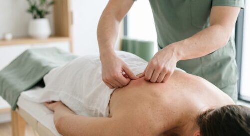 Massagem relaxante ou terapêutica: qual a diferença e como escolher Massoterapia em Curitiba no Espaco TAO, um massoterapeuta realizando massagem relaxante nas costas de paciente em maca, identificando os ponto-gatilho envolvidos na dor