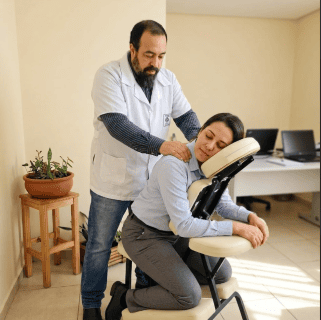 Massoterapia Corporativa e NR-01: Como Promover Saúde e Segurança no Trabalho. Funcionária sentada em uma cadeira de quick massage ergonomicamente posicionada no ambiente de trabalho.